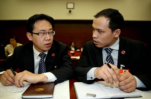 3月9日,董林(右)在山西代表團(tuán)全體會(huì)議上與全國(guó)人大代表石文斌交談。新華社記者 陳建力 攝