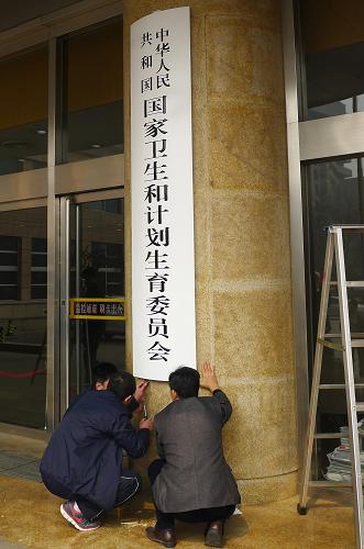 3月17日,工作人員在原衛(wèi)生部大樓門口更換新牌。當(dāng)日上午11時許,原衛(wèi)生部大樓門口更換了“國家衛(wèi)生和計劃生育委員會”的新牌。新華社記者 呂諾 攝