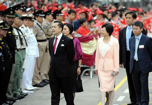 這是香港特區(qū)署理行政長(zhǎng)官黃仁龍(前左)出席升旗儀式。 新華社記者 宋振平 攝