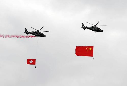 10月1日,香港特別行政區(qū)在金紫荊廣場舉行升旗儀式,慶祝中華人民共和國成立60周年。這是兩架分別懸掛中華人民共和國國旗、香港特區(qū)區(qū)旗的直升機從空中飛過。 新華社記者 陳鐸 攝