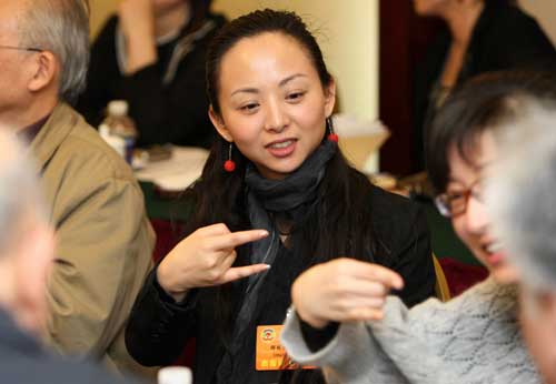 3月4日,中國殘疾人藝術團藝術總監(jiān)邰麗華委員在通過手語翻譯與其他委員交流。新任全國政協(xié)委員的邰麗華準備在這次會議上提交一份關于進一步完善殘疾人無障礙信息等方面政策的提案。 新華社記者 龐興雷 攝