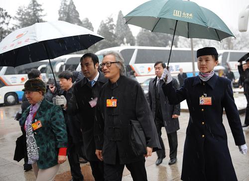 3月14日,第十一屆全國人民代表大會第三次會議將在北京人民大會堂舉行閉幕會。北京下起了雨夾雪,工作人員打著傘迎接代表。新華社記者 楊宗友 攝