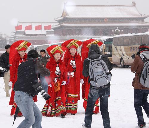 3月8日是國際勞動(dòng)?jì)D女節(jié),一場(chǎng)春雪降臨京城,身著紅色民族服裝服務(wù)兩會(huì)的廣西大廈服務(wù)人員來到天安門廣場(chǎng),在白雪的映襯下分外靚麗,成為記者拍攝的焦點(diǎn)。 新華社記者 陳建力 攝