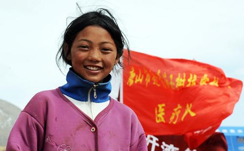 玉樹地震災區(qū)結古鎮(zhèn)的藏族姑娘拉毛站在自家?guī)づ窀浇囊惶庒t(yī)療救治點旁(4月22日攝)。一場無情的地震損毀了美麗的家園,來自四面八方的援助在廢墟上重新點燃希望,玉樹人民在全國人民的幫助下,從廢墟中搜尋生產(chǎn)生活物品,開展生產(chǎn)生活自救;學生在搭建的帳篷里上課學習,清脆的讀書聲讓這片土地重新煥發(fā)生機;朝佛的路上,堅毅的身影丈量著前進的步伐,彰顯著生命的頑強。擦干眼淚,挺起脊梁的玉樹人從廢墟中走出來,用雙手繪就暢想明天的畫卷。千年的唐蕃古道,千年的雪域重鎮(zhèn),玉樹地震災區(qū)的人們,用剛強和樂觀面對困苦,與億萬同胞一起投身于重建家園的再造工程。新華社記者 侯德強 攝