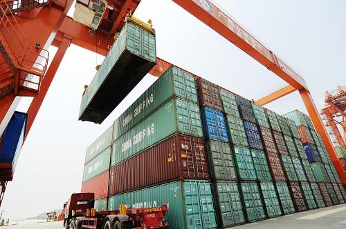 在廣西欽州保稅港區(qū)碼頭,貨車在裝運集裝箱(6月1日攝)。新華社發(fā)(梁富盈 攝)