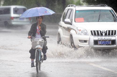 8月5日,一名市民在吉林市街頭冒雨騎行。當日,吉林省吉林市再次遭遇強降雨。大到暴雨天氣不僅給市民生活帶來不便,也使防汛抗洪工作形勢更加嚴峻。新華社記者 徐家軍 攝