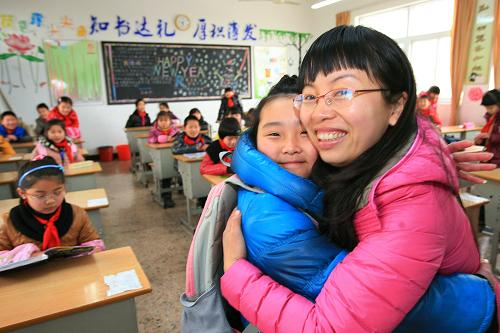 2月7日,浙江省紹興縣中國輕紡城小學四年級(5)班班主任金燕老師,給開學到校的學生送上擁抱。當日是新學期開學第一天,紹興縣中國輕紡城小學的老師們向返校學生贈送擁抱,讓學生們感受輕松與溫馨。新華社發(fā)(高潔 攝)