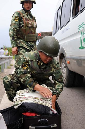 邊防干警在勐混查緝點對可疑人員的行李進(jìn)行檢查(6月16日攝)。新華社記者 藺以光 攝