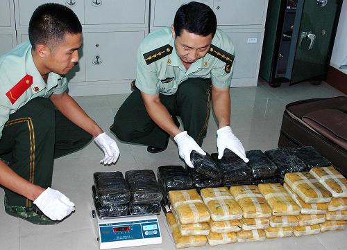 云南西雙版納邊防支隊的干警對查獲的海洛因和冰毒進(jìn)行核稱、登記,準(zhǔn)備封存(6月18日攝)。楊孟龍攝(新華社發(fā))