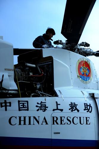 地面機(jī)械師對(duì)救助直升機(jī)進(jìn)行檢修、維護(hù)(11月25日攝)。新華社記者 李勇 攝