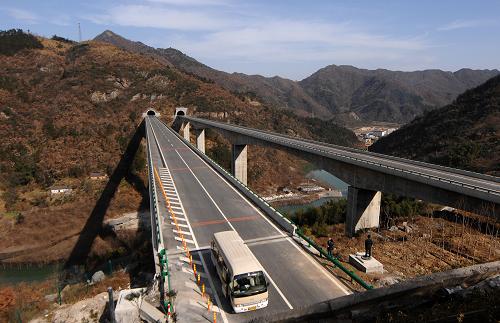 12月5日,一輛工程用車行駛在剛剛完工的六潛高速公路磨子潭特大橋路段。穿越大別山革命老區(qū)的安徽六(安)潛(山)高速公路主體工程全面完工,本月即將實現(xiàn)通車。六(安)潛(山)高速公路是國家重點公路規(guī)劃的重要路段,全長150公里,工程概算總投資92.03億元,由于主要穿行區(qū)域均在大別山革命老區(qū)而被稱為“紅色高速”。新華社記者 王雷 攝