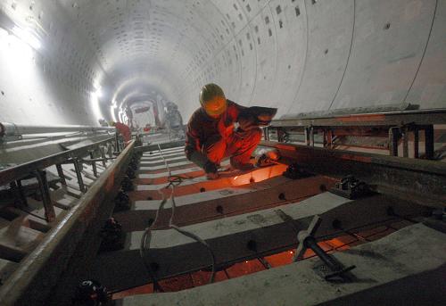 3月17日,建設(shè)者在上海軌道交通7號(hào)線隧道內(nèi)鋪軌。 新華社發(fā)