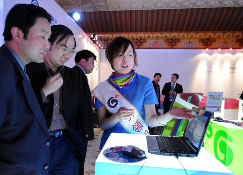 5月9日,一位服務(wù)人員正在向參觀者介紹3G商用業(yè)務(wù)。 新華社記者 覺(jué)果 攝