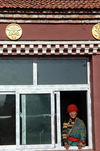 青海省黃南藏族自治州澤庫縣一生態(tài)移民村內(nèi),一名藏族小姑娘在家中向外眺望(12月25日攝)。新華社記者 張宏祥 攝