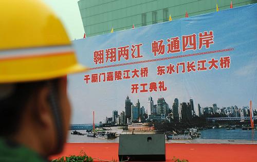 12月29日,一位工人在觀看“兩江大橋”效果圖。12月29日,分別橫跨長江和嘉陵江的東水門長江大橋和千廝門嘉陵江大橋(以下簡稱“兩江大橋”)在重慶市主城區(qū)同時動工。“兩江大橋”是一對姊妹橋,兩橋之間用隧道相連,擔(dān)負(fù)連接重慶主城解放碑、江北城、彈子石“金三角”交通的重要功能。“兩江大橋”為公軌兩用橋梁,即橋上為汽車跑道,橋下面為軌道交通。汽車跑道為雙向四車道,設(shè)計行車時速為每小時40公里;軌道交通設(shè)計時速為每小時100公里,總投資15億元。新華社發(fā)