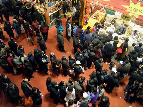 1月24日,人們?cè)诘谌龑弥貞c新春年貨購(gòu)物節(jié)上排隊(duì)購(gòu)買(mǎi)食品。 新華社發(fā)(孟昭曜 攝)