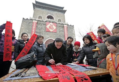 2月6日,在北京鐘鼓樓廣場舉行的“文明春聯(lián)進(jìn)萬家”活動上,書法家為社區(qū)居民寫春聯(lián)。 新華社發(fā)(江峻 攝)