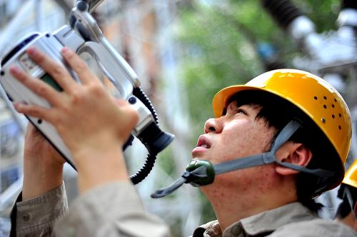 7月27日,天津城西供電分公司供電職工用紅外線探測儀監(jiān)測變電設(shè)備運行情況。進(jìn)入“三伏”以來,天津用電負(fù)荷達(dá)到996.7萬千瓦,打破2009年最高用電負(fù)荷記錄。隨著大乙烯、大火箭等一大批國家重點工業(yè)項目陸續(xù)落戶天津濱海新區(qū),天津市用電負(fù)荷預(yù)計將突破1000萬千瓦大關(guān)。為“全方位”保障電網(wǎng)安全運行,國家電網(wǎng)天津電力部門在充分做好各類事故預(yù)想和應(yīng)急預(yù)案的同時,一支由1200人組成的電力保障應(yīng)急隊伍嚴(yán)陣以待,全力保障電網(wǎng)安全可靠運行。 新華社記者 劉海峰 攝