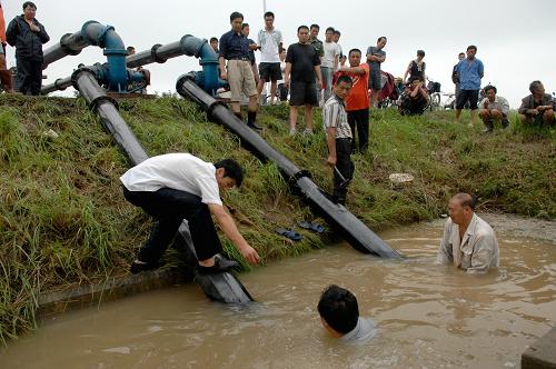 9月8日,工人在江蘇宿遷市宿豫區(qū)外環(huán)路上安裝抽水機。 9月7日至8日晨,江蘇省宿遷市遭遇特大暴雨,市區(qū)降雨量達289.2毫米,最大降水量高達340毫米,日降雨量創(chuàng)有記錄以來極值。宿遷市正全力應(yīng)對極值暴雨對當(dāng)?shù)厣a(chǎn)生活造成的影響,全面開展防汛抗災(zāi)各項工作。目前,市區(qū)大部分地區(qū)水位已明顯下降,內(nèi)澇情況得到有效緩解。 新華社發(fā)