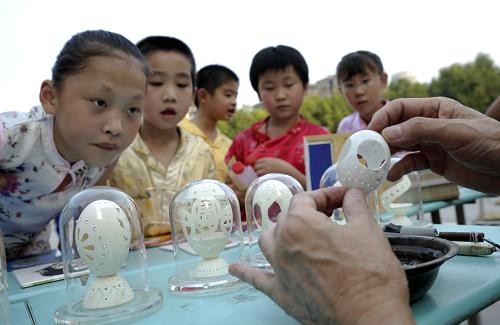 9月21日,合肥市屯溪路小學(xué)的幾名學(xué)生觀看蛋雕制作。 當(dāng)日,安徽省合肥市屯溪路小學(xué)舉行聯(lián)歡及民俗展示活動(dòng),迎接中秋節(jié)。孩子們在體驗(yàn)刺繡、猜燈謎等民俗活動(dòng)的同時(shí)感受傳統(tǒng)文化的魅力。 新華社發(fā)(虞俊杰 攝)