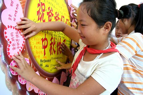 9月21日,在安徽含山縣關(guān)鎮(zhèn)小學(xué),留守兒童在制作“愛(ài)心大月餅”。 當(dāng)日,安徽含山縣關(guān)鎮(zhèn)小學(xué)開(kāi)展中秋節(jié)感恩教育活動(dòng),留守兒童們親手制作中秋節(jié)賀卡,并用賀卡拼出“愛(ài)心大月餅”,表達(dá)對(duì)在外打工父母的思念和感恩之情。 新華社發(fā)(程千俊 攝)