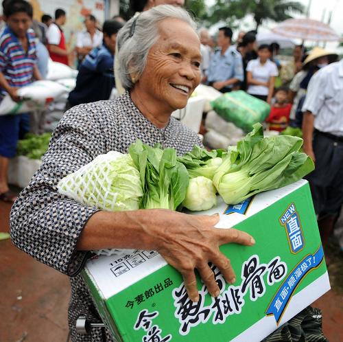 10月9日,一位海南省萬寧市和樂鎮(zhèn)老人領(lǐng)到蔬菜和其他救災(zāi)物資。新華社記者侯建森攝