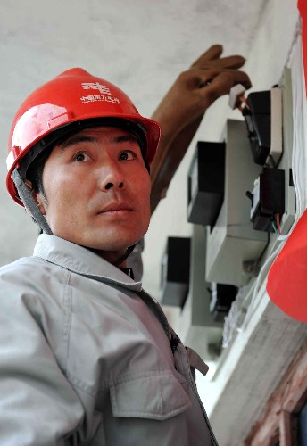 3月3日,在貴州省六盤水市水城縣董地鄉(xiāng)穆家寨村舉行的復(fù)電儀式上,南方電網(wǎng)六盤水供電局的一名搶險(xiǎn)人員正在為災(zāi)民陳勝華家復(fù)電合電閘。當(dāng)日,經(jīng)過南方電網(wǎng)六盤水市4萬多名電力職工、縣、鄉(xiāng)干部以及民兵應(yīng)急分隊(duì)的全力搶險(xiǎn),貴州省六盤水市因受凝凍災(zāi)害而斷電的最后一個(gè)村舉行了復(fù)電儀式,至此,全市因凝凍災(zāi)害停電的村已全部恢復(fù)通電。