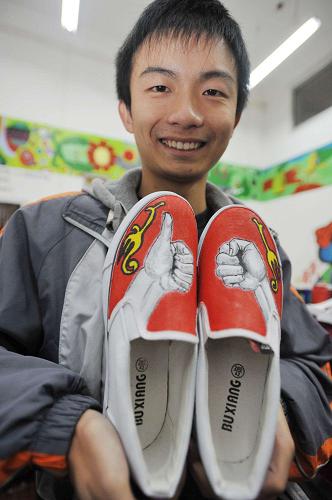 12月3日,一名聾啞學(xué)生在展示自己手工彩繪的布鞋。新華社記者歐東衢攝