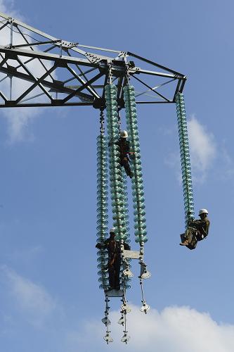 8月4日,工人在三峽大壩右岸秭歸縣羅家村境內(nèi)的電塔上進(jìn)行安裝作業(yè)。三峽地下電站至荊門換流站500千伏輸電線路工程,起于三峽大壩右岸,止于湖北省荊門市,該輸電線路沿線多為山嶺地帶,施工難度大。為確保該線路今年年底全面竣工,工人們?cè)诳崾罴竟?jié)避開高溫時(shí)段作業(yè),力爭(zhēng)按時(shí)完成施工進(jìn)度。