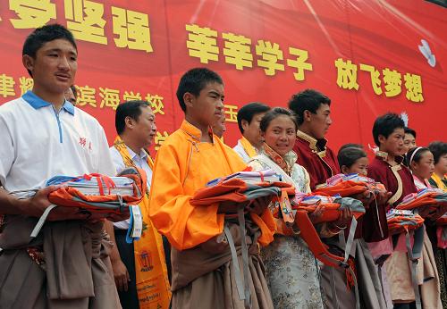 9月5日,來(lái)自玉樹(shù)的學(xué)生在開(kāi)學(xué)典禮上領(lǐng)到課本和書(shū)包。當(dāng)日,天津東麗區(qū)耀華濱海學(xué)校為517名玉樹(shù)地震災(zāi)區(qū)初一學(xué)生在該校就讀舉行開(kāi)學(xué)典禮。據(jù)介紹,這些學(xué)生將按照教育部的統(tǒng)一部署,在這里進(jìn)行為期兩年的學(xué)習(xí)生活。