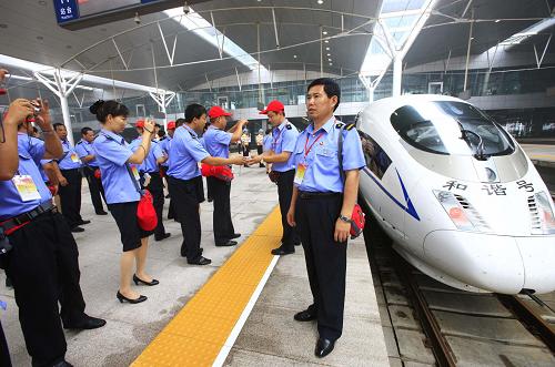 8月26日,鐵路系統(tǒng)的先進(jìn)模范代表在天津火車站與“和諧號”京津城際高速列車合影。 新華社記者 李明放 攝