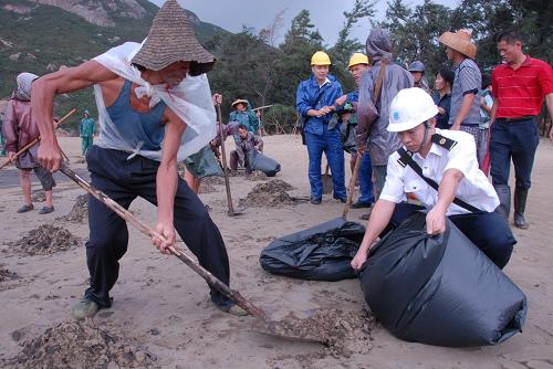 9月15日,珠海海事局組織清污人員在清除海灘上的油污。因受臺(tái)風(fēng)“巨爵”襲擊,一艘巴拿馬籍集裝箱船在珠海高欄島水域擱淺,船方自報(bào)泄漏燃油50噸。廣東海事部門緊急啟動(dòng)溢油應(yīng)急預(yù)案,部署落實(shí)應(yīng)急措施,派出人員前往油污水域查勘,組織清污船只、社會(huì)力量及時(shí)對(duì)海岸進(jìn)行清污。 新華社發(fā)(曾志遠(yuǎn) 攝)