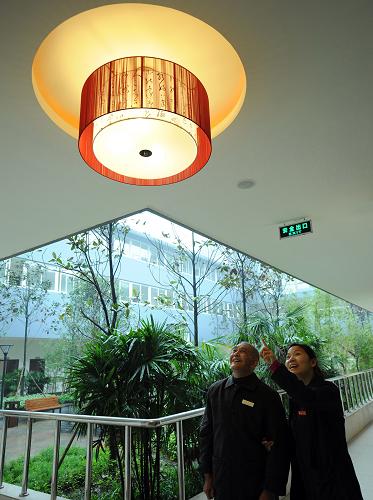 10月26日,一名黨員義工(右)正帶著尹光宗老人在院內(nèi)參觀。新華社記者 周衡義 攝