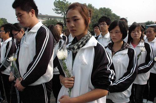 10月28日,長(zhǎng)江大學(xué)的學(xué)生們手持菊花悼念逝去的同學(xué)。 新華社記者 魏夢(mèng)佳 攝