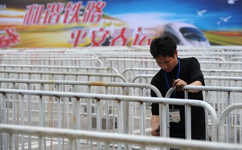 1月20日,工作人員在廣州交易會流花展館春運火車票集中售取票點布置隔離欄。新華社記者 劉大偉 攝
