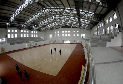 2月23日,幾名學(xué)生和家長在新建的綿竹中學(xué)的室內(nèi)球場參觀。新華社發(fā)(王平 攝)