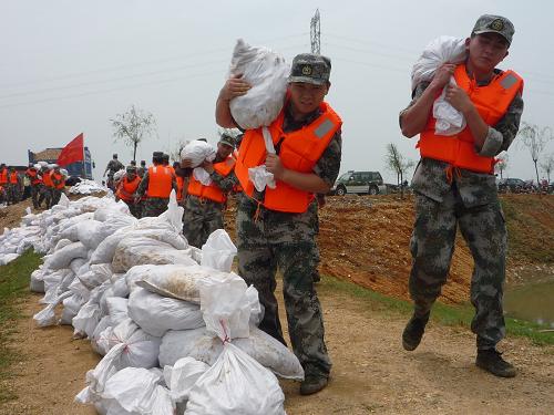 6月21日,江西某預備役炮兵團官兵在吉安市吉州區(qū)曲瀨大堤搬運沙袋塞堵缺口。當日中午13時,江西省吉安市吉州區(qū)曲瀨大堤出現(xiàn)險情,吉州區(qū)曲瀨鄉(xiāng)數(shù)十個村莊被淹。江西某預備役炮兵團迅速前往馳援,幫助疏散村民并搶救群眾財產(chǎn)。新華社發(fā)(宋志奎 攝)