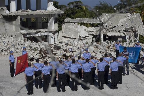 1月12日,在海地首都太子港,中國赴海地維和警察防暴隊隊員們在聯(lián)合國駐海地穩(wěn)定特派團(聯(lián)海團)總部舊址廢墟前舉行儀式,悼念在去年地震中遇難的戰(zhàn)友。2010年1月12日,海地發(fā)生里氏7.3級強烈地震,8位中國維和警察在地震中不幸遇難。新華社發(fā)