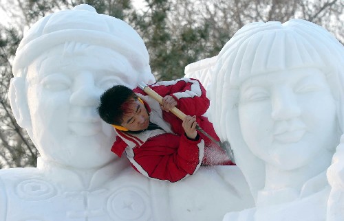 12月20日,一名雪雕藝人在太陽島雪博會上修飾雪雕作品。新華社記者 李勇 攝