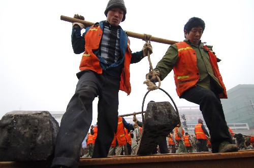 12月21日,中鐵四局八公司的鐵路工人正在合肥站鋪設(shè)鐵軌。新華社記者 李健 攝