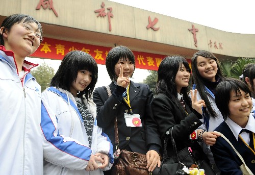 3月11日,日本青少年友好使者代表團(tuán)成員在成都市第七中學(xué)參觀結(jié)束后,與中國學(xué)生在校門前合影留念。新華社記者 陳凱 攝