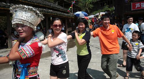 10月6日,在廣西融水苗族自治縣溝灘苗寨,游客和當(dāng)?shù)孛缱迩嗄晖嬗螒颉?“十一”長(zhǎng)假以來(lái),廣西融水縣獨(dú)特的苗族風(fēng)情吸引了四面八方的游客,溝灘、雨卜、田頭和龍女溝等苗寨旅游景點(diǎn)持續(xù)火爆。新華社發(fā)(龍濤 攝)