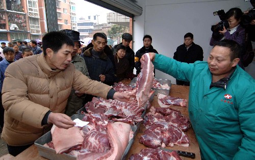 1月22日,一名員工在平價“愛心豬肉”供應(yīng)點(diǎn)熱情地向困難群眾推薦豬肉。為讓困難群眾能夠吃上豐盛的年夜飯,重慶市大渡口區(qū)近日聯(lián)合“愛心”企業(yè)向困難群眾發(fā)放了數(shù)千張“愛心豬肉”免費(fèi)供應(yīng)券,并多方組織豬肉貨源,向轄區(qū)內(nèi)的城市貧困人口和農(nóng)村居民提供低于市場價格的平價“愛心豬肉”。 新華社記者 劉潺 攝