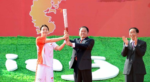 5月9日,惠州市市委書記黃業(yè)斌(中)將火炬交給惠州市第一棒火炬手陳秀君(左)。當(dāng)日,北京奧運(yùn)圣火傳遞活動(dòng)在廣東省惠州市舉行。 新華社記者劉力航攝