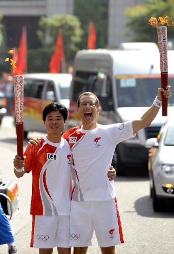 5月9日,奧運(yùn)火炬手伯尼耶(右)與李家聲在傳遞過(guò)程中交接。當(dāng)日,北京奧運(yùn)圣火傳遞活動(dòng)在廣東省惠州市舉行。 新華社記者劉大偉攝