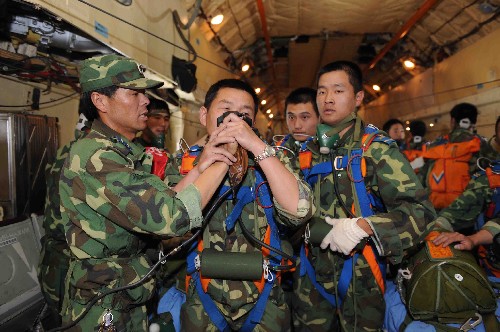 5月17日,空投員在空投前補(bǔ)充氧氣。當(dāng)日,空軍伊爾-76大型運(yùn)輸機(jī)在四川省北川縣片口鄉(xiāng)、壩底鄉(xiāng)等重災(zāi)區(qū)實(shí)施空投。由于當(dāng)?shù)厣礁?,運(yùn)輸機(jī)必須在5500米以上的高空飛行??战当巢渴褂米孕醒兄频谋銛y式氧氣裝置,解決空投員高空缺氧問(wèn)題,順利完成5500米高空的救災(zāi)物資空投任務(wù)。 新華社發(fā)(沈玲 攝)