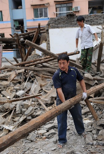 5月20日,四川省青川縣群眾在廢墟中找尋可用的建材。連日來,地震重災(zāi)區(qū)青川縣的各族群眾積極應(yīng)對(duì)災(zāi)情,不屈不撓,斗志昂揚(yáng),準(zhǔn)備在黨和政府的幫助下重建家園。 新華社記者 藺以光 攝