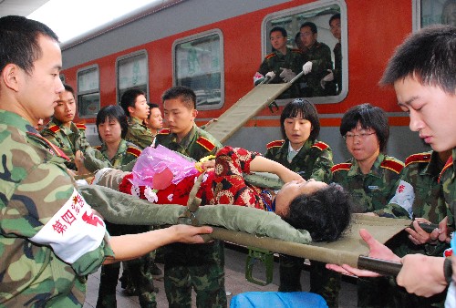 5月21日,在西安火車站,第四軍醫(yī)大學的醫(yī)護人員運送重傷員。 當日6時58分,載著來自四川重災區(qū)248名傷員的專列??吭谖靼不疖囌荆@批傷員被迅速轉運到第四軍醫(yī)大學所屬的西京醫(yī)院和唐都醫(yī)院。這是四川汶川大地震后被送往陜西省進行救治的首批重傷員。 新華社發(fā)(祁小軍 攝)