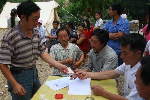 5月28日,青川縣喬莊鎮(zhèn)大溝村受災戶在發(fā)放點領取補助金。 自5月28日起,四川青川縣對因地震造成的無房可住、無生產資料和無收入來源的困難群眾實施臨時生活救助,救助標準為每人每天10元、0.5公斤成品糧,“三孤”人員的補助標準為每人每月600元,救助期限為3個月。 新華社發(fā)(劉忠俊 攝)