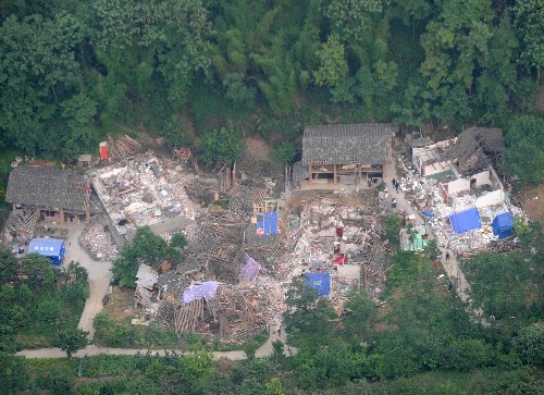 在四川省北川縣,一些受災群眾住在廢墟旁的帳篷里(5月26日攝)。 汶川地震發(fā)生后,帳篷成了許多受災群眾臨時的家。據四川抗震救災指揮部提供的消息,截至5月28日,已有44.7萬頂帳篷下?lián)芩拇膮^(qū),尚需帳篷157萬頂。 新華社記者 王曄彪 攝